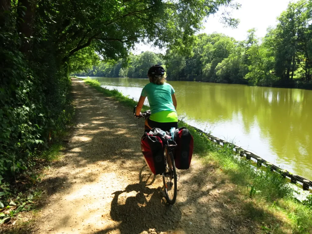 Canal du Midi à Portiragnes, bordé d’arbres et traversé par des cyclistes en balade